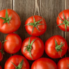 Close-up of fresh, ripe tomatoes on wood background