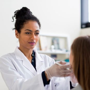 cosmetic plastic surgeon examining patient