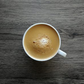 Coffee mocha in a white cup on a black wooden table.