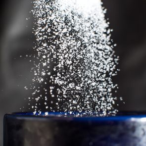 Sugar pouring down into blue cup