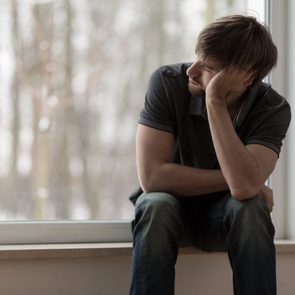 Young miserable depressed man sitting and thinking