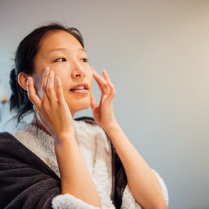 A young woman is washing her face