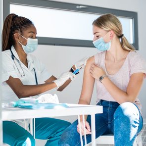 Woman with face mask getting vaccinated, coronavirus concept.