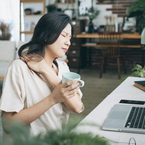 Asian woman struggling with using laptop at home