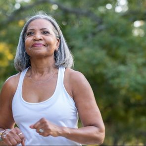 Senior woman jogging in public park