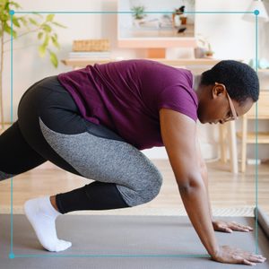 woman practicing yoga at home on a yoga mat